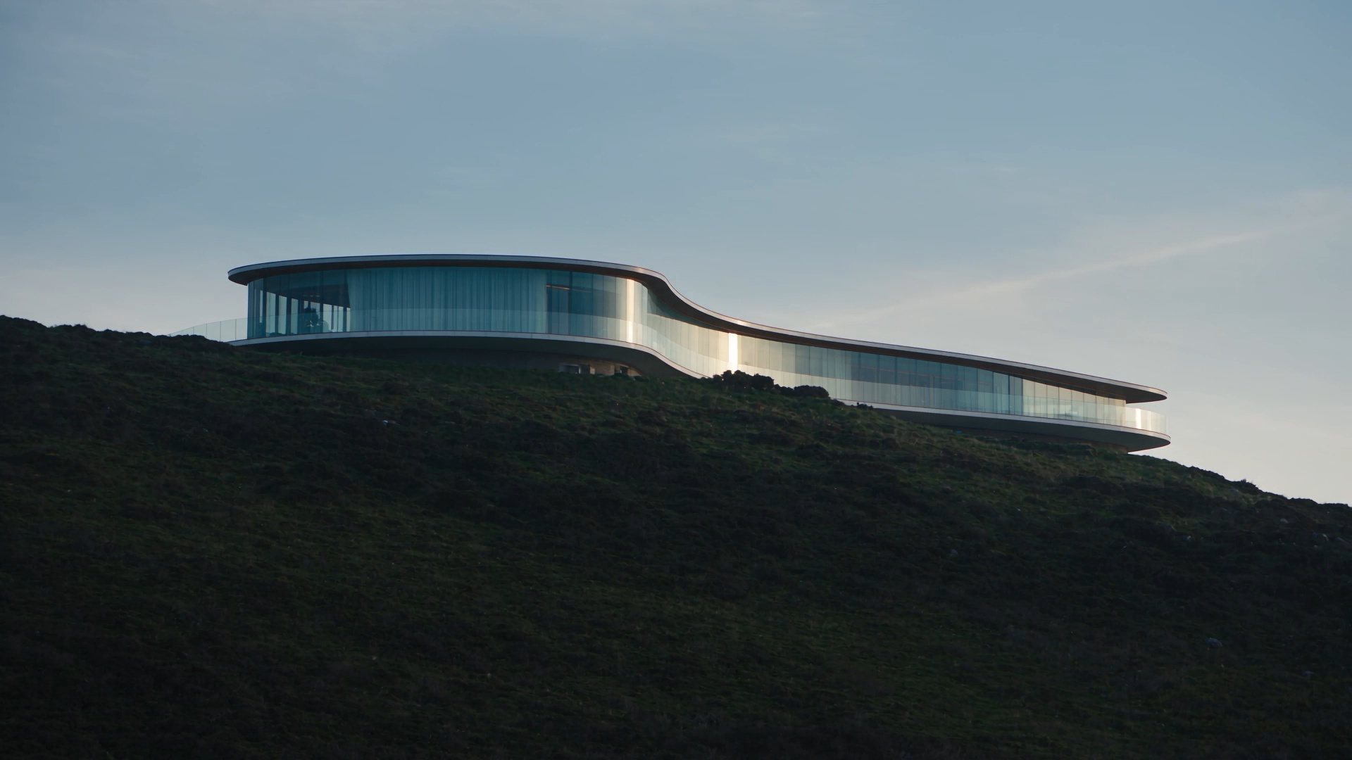 A glass building on a hillside at dusk, from the Amersia reel