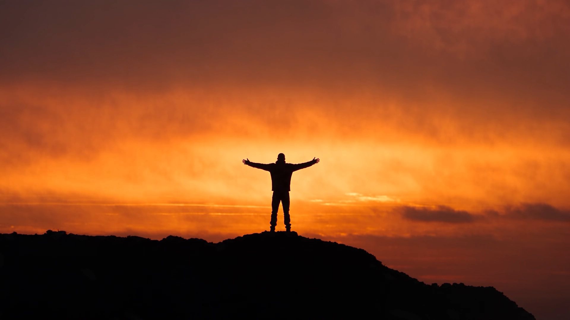 A figure with arms outstretched on a ridge at sunrise, from the Amersia reel
